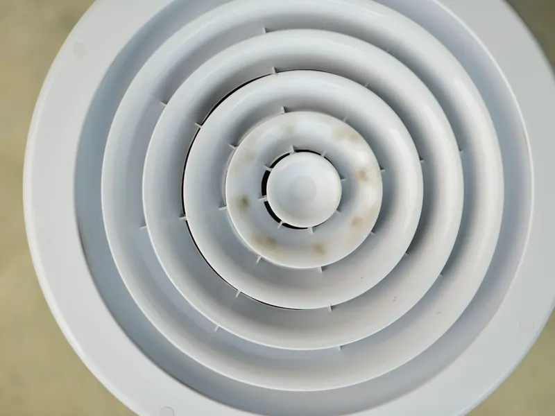 Round ceiling air vent in a home served by repaired and sealed ductwork